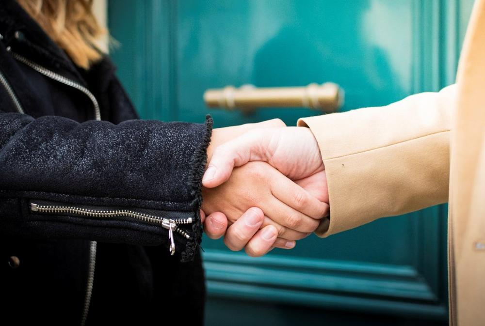 Poignée de mains entre une cliente et un conseiller Century 21